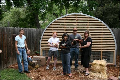 wood framed quonset hut chicken coop with people holding chickens