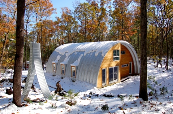 Q model quonset hut home with custom wooden endwall with lots of window in the front and on the sides