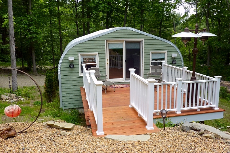 A model quonset hut man cave with front porch and green custom endwall with windows and sliding doors