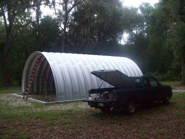 construction of small Quonset Hut with truck next to it