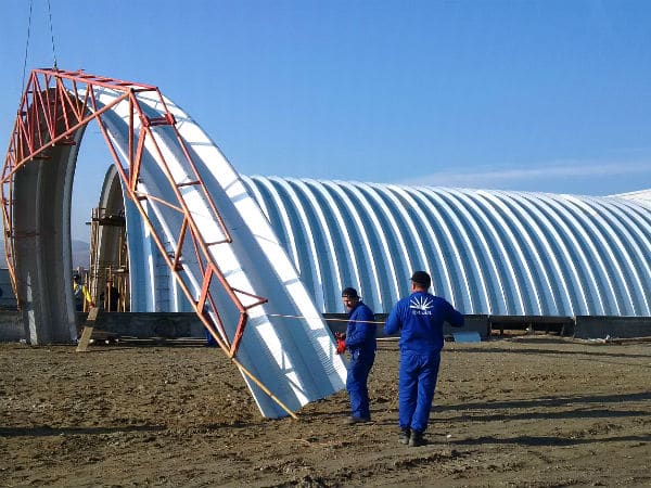 steel quonset hut mid construction with arch raised in air