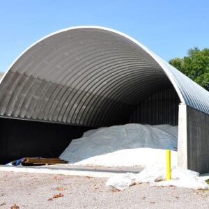 arch steel roof mounted on concrete walls and solid back endwall with pile of salt inside