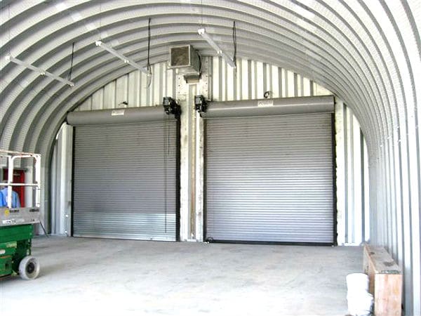 inside steel quonset hut with two metal roll up garage doors