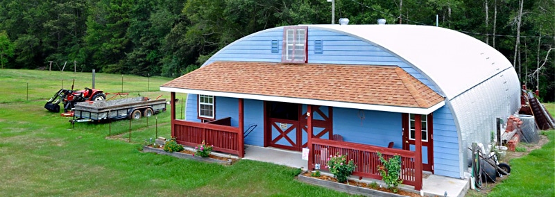 blue quonset hut home with porch attached to endwall