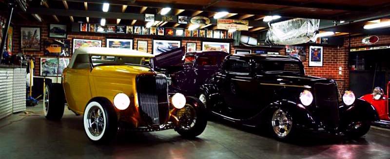 interior of steel garage with two hot rod vintage cars