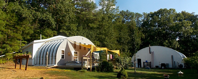 custom steel quonset home with yellow awning and matching steel garage 