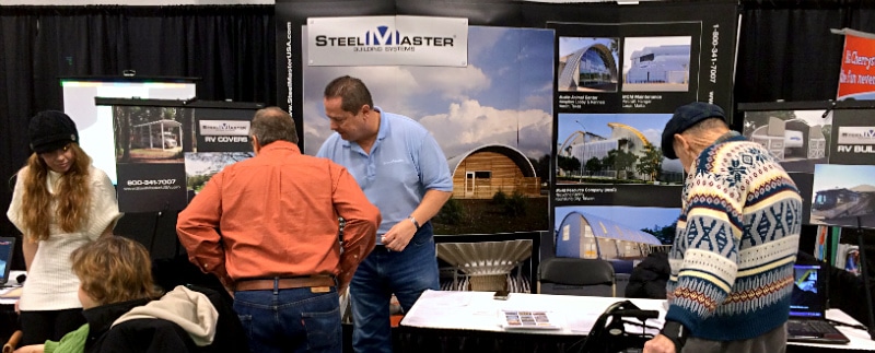 trade show with customers looking at steel building booth