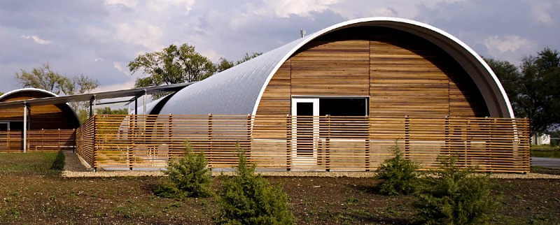 custom steel building Quonset Hut with wooden fence and custom endwalls