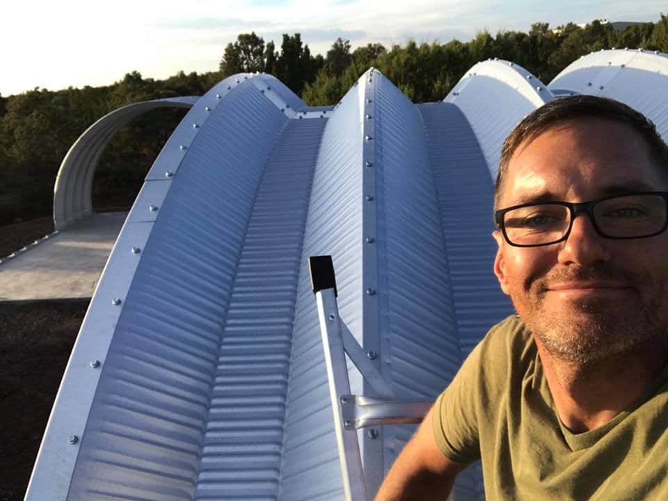Architect poses with quonset huts