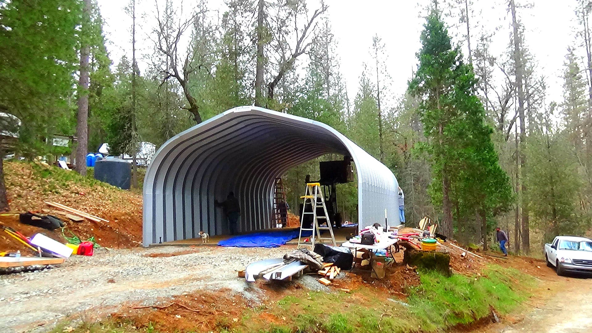working site with open-ended quonset hut mid-construction