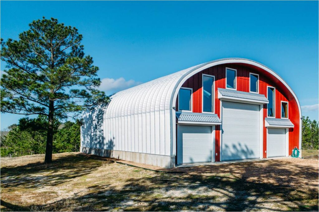 Quonset hut steel arch red paneled front three garage doors barn type
