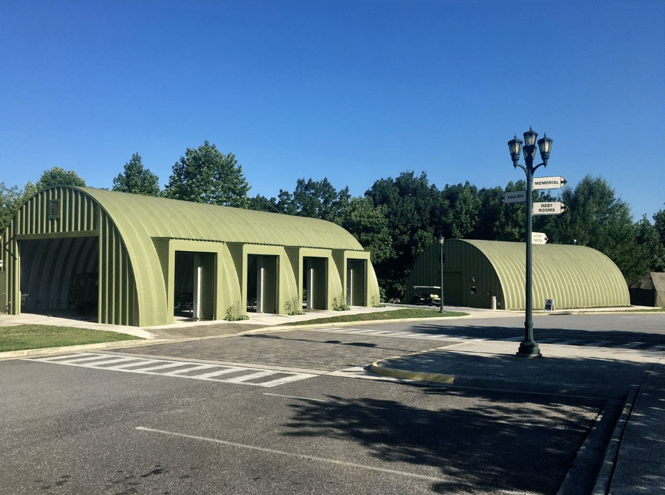 two green quonset huts, one with four side openings in the walls