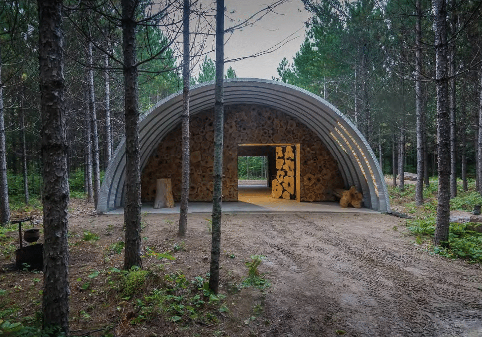 workshop quonset hut with porch overhang and custom endwalls made from logs