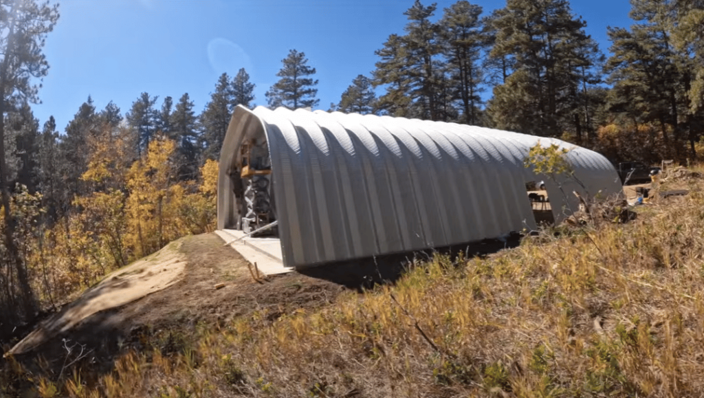 Quonset hut on top of hill surounded by trees