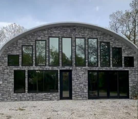 Viral Quonset Hut home with custom stone endwall and windows