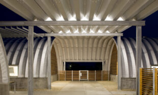 Inside of a Q-Model Quonset hut with opening in the middle, and two Quonsets on the sides.