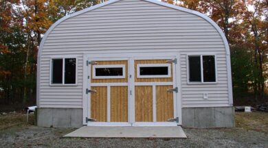 A-Model Quonset workshop with custom beige vinyl front end wall and custom wooden double doors