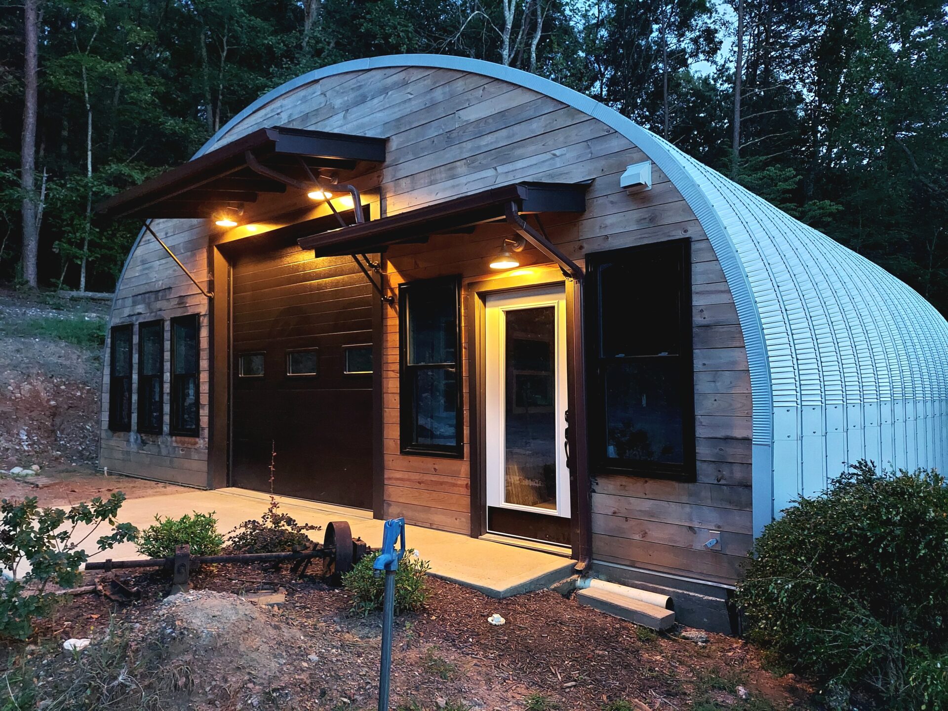 S-Model workshop with wooden front end wall, black garage door, and white entry door