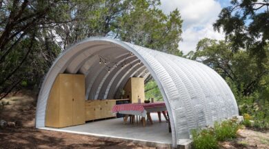 Open ended Q-Model Quonset hut covering a picnic table with a checkered table cloth and a row of custom cabinets