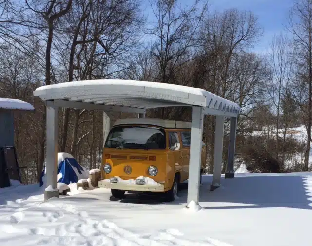 Yellow Volkswagen covered by steel carport