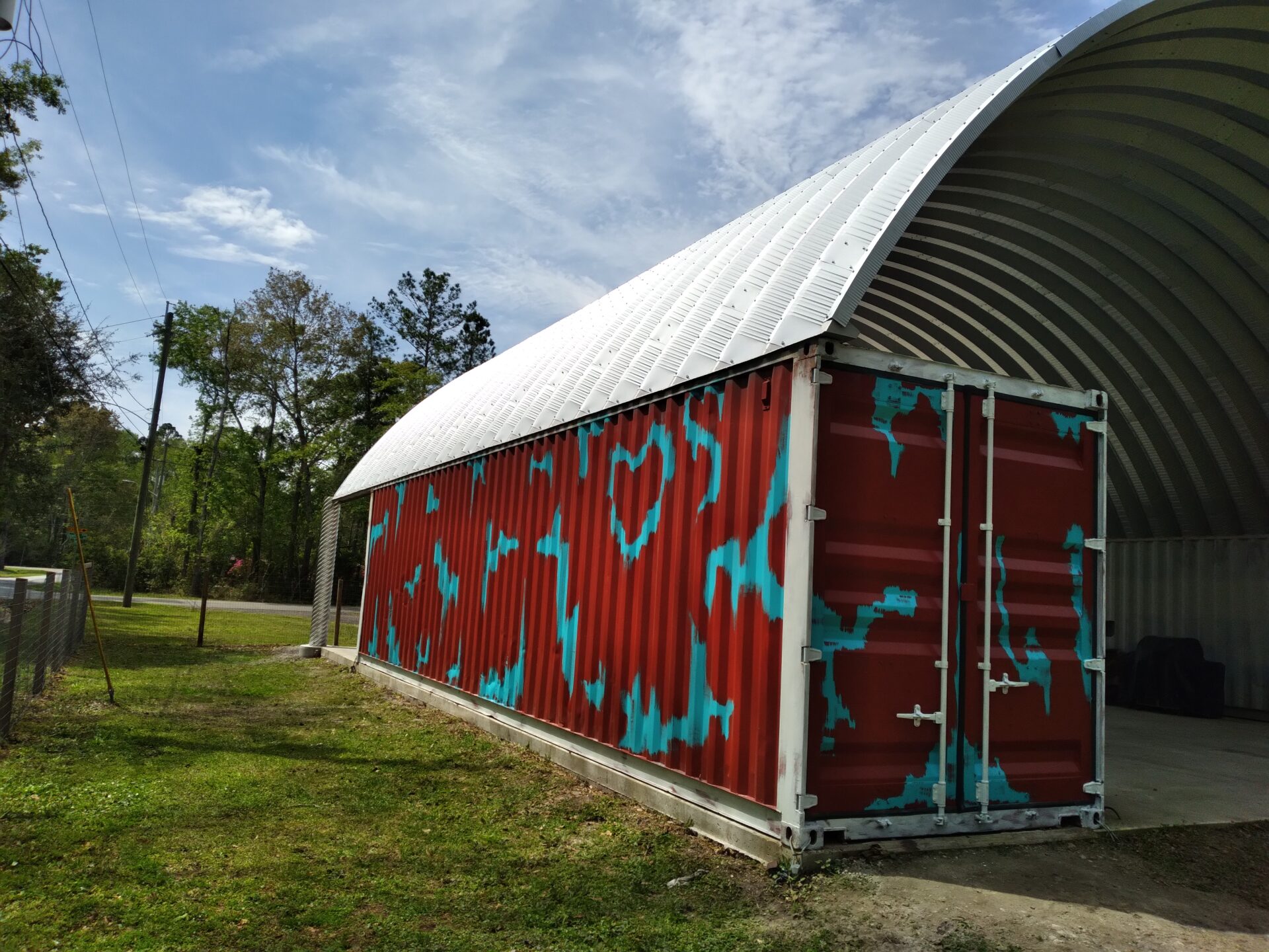 steel arch roof mounted on multicolor red and blue shipping container