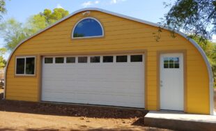 A-Model Quonset workshop with bright yellow front end wall, white double garage door and white entry door