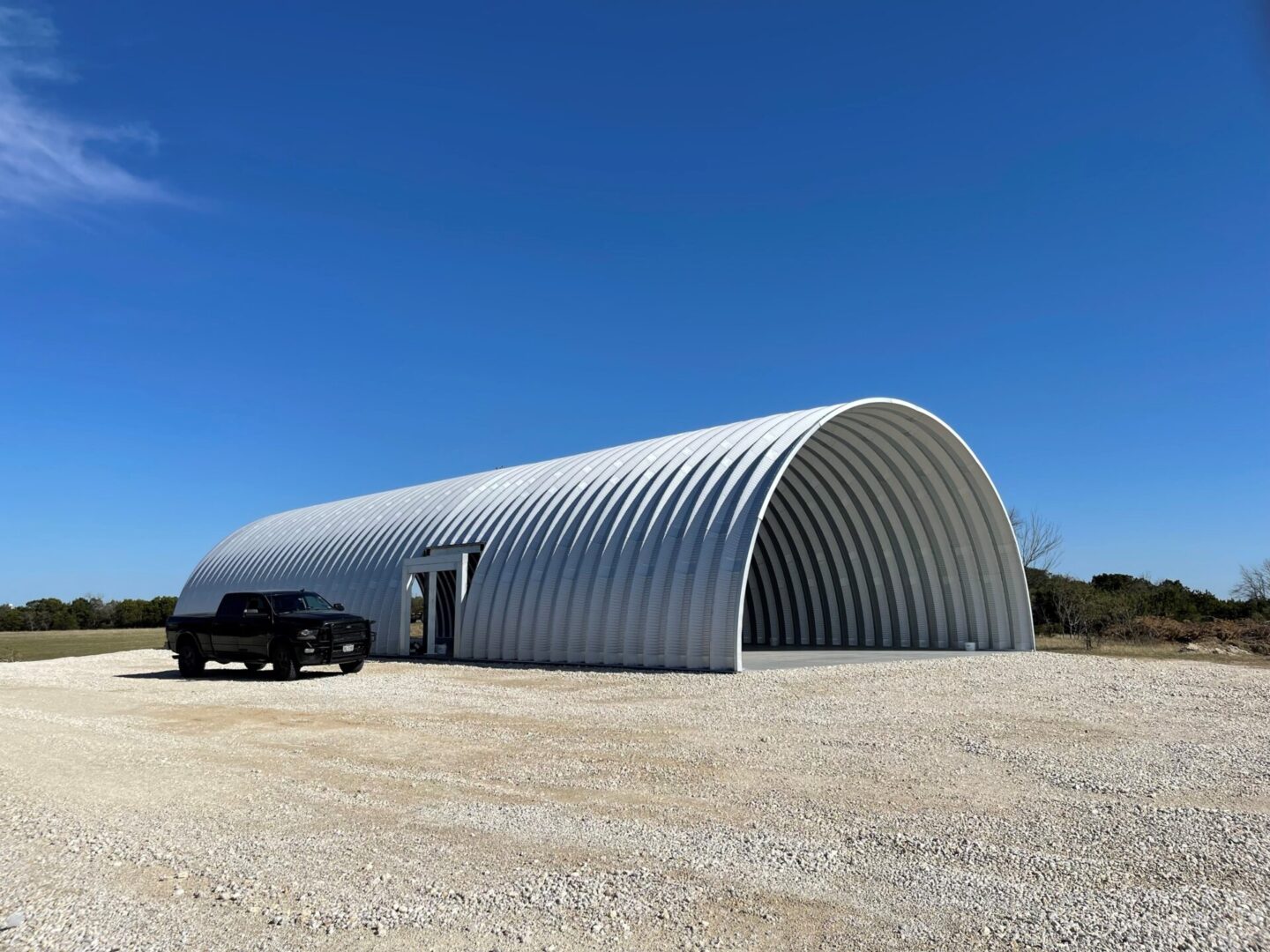 q model steel open ended storage building with gravel all around and truck parked next to it