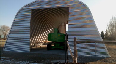 X-Model Quonset hut with green farm equipment inside