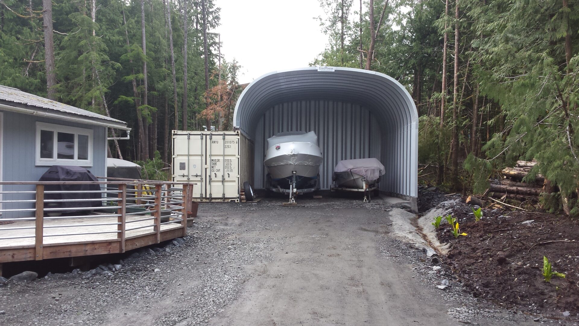 s model steel storage building with steel rear endwall and open front wall with two boats inside