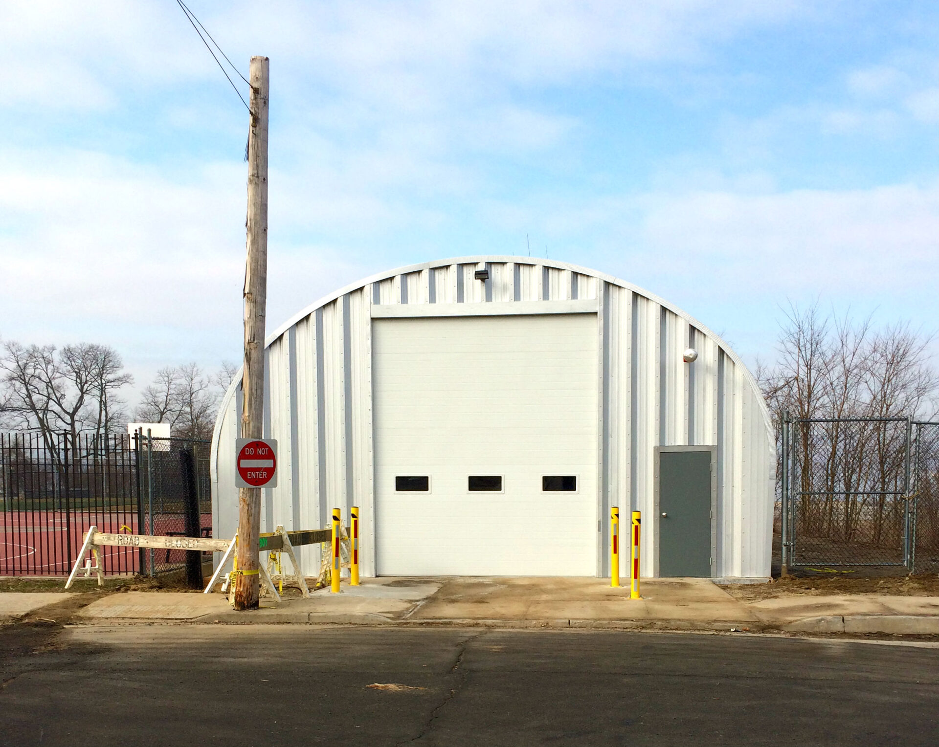 S model steel arch building with white garage door with three windows on it and a walk through door used at fire department in NY