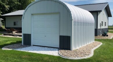 steel S model storage shed with custom white and grey front endwall and landscaping around the building and house behind it