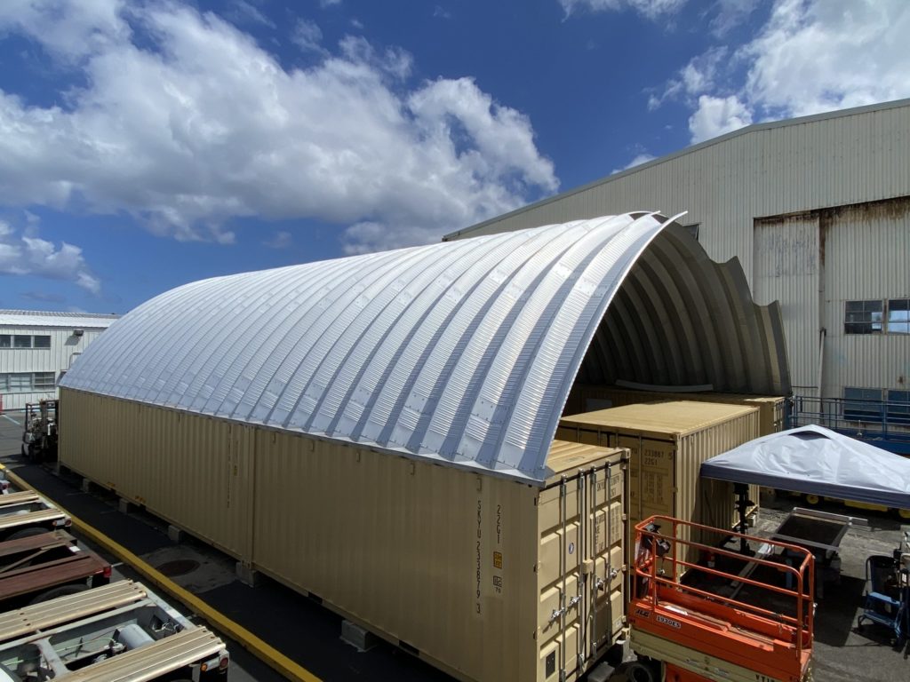 Maintenance shelter made up of steel arches and freight containers.