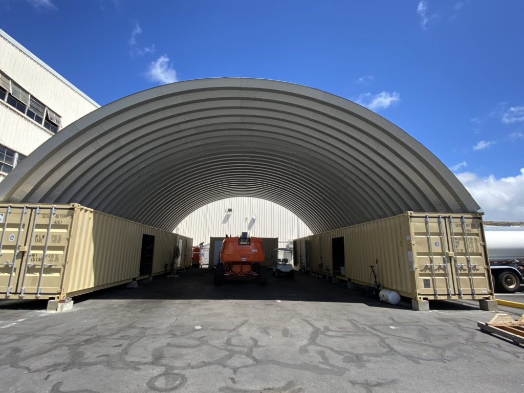 Container cover building sheltering heavy machinery.