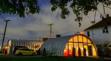 exterior of steel building quonset style structures used for many different uses with custom endwalls and windows in the evening