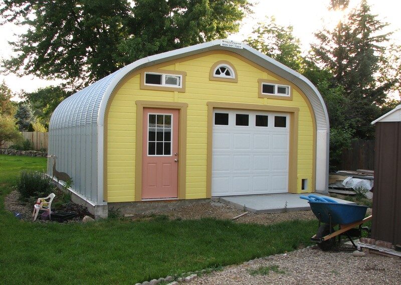 A model shed building with custom yellow front endwall and peach door with white garage door and little windows