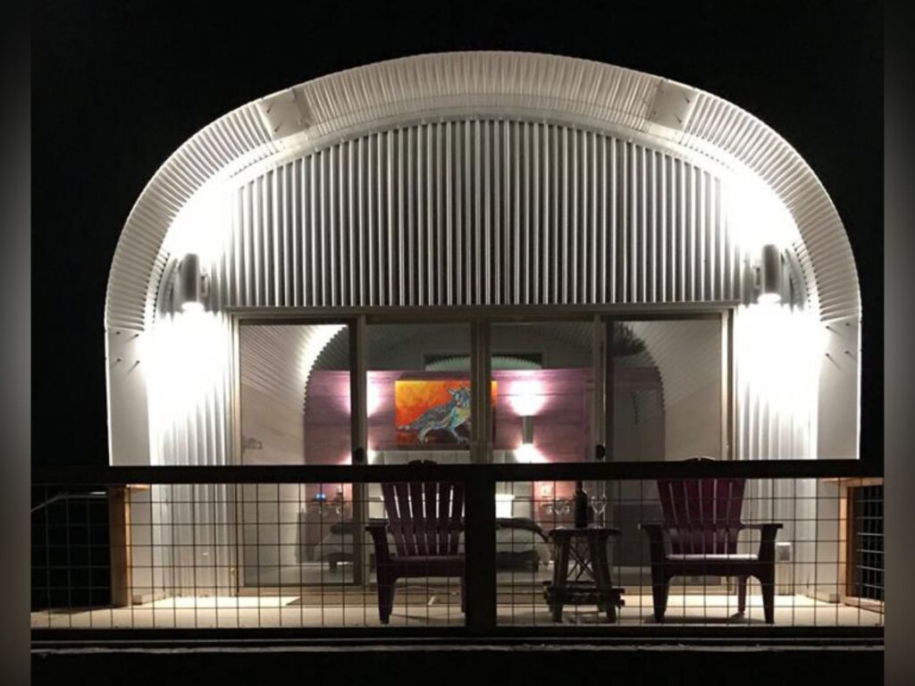 Finished Quonset casita, terrace with sitting area, glass doors and windows, custom front with grey exterior.