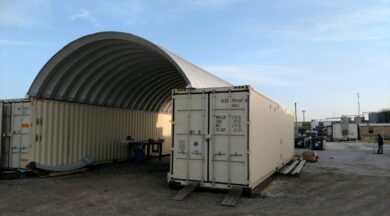 container roof system in on top of beige shipping containers