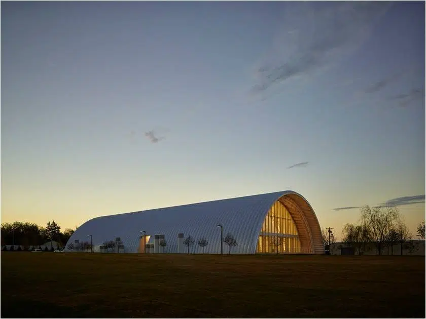 sideview of q-model quonset structure at dusk, glass endwall, side entrance