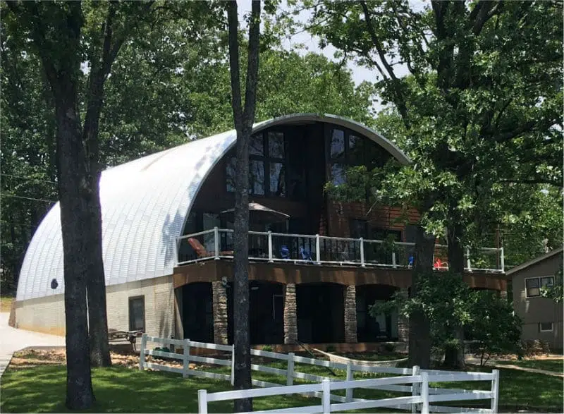 Finished two story S-model Quonset home with custom endwall, stone pillars, and a balcony.