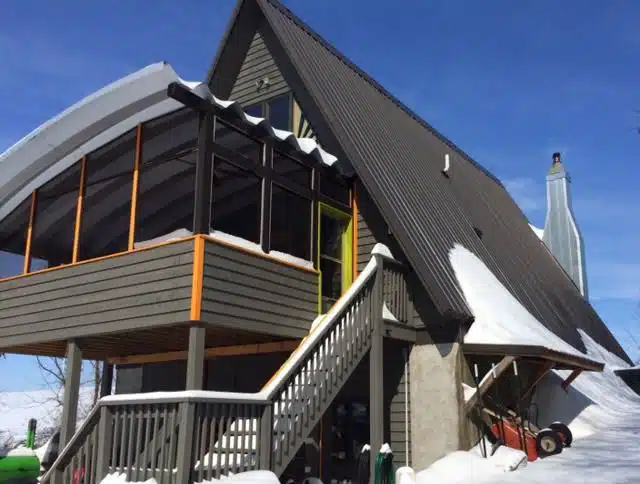 Snowy custom Quonset hut arch covering sun roof of home