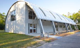 Arched roofing system forming awning over porch area next to building