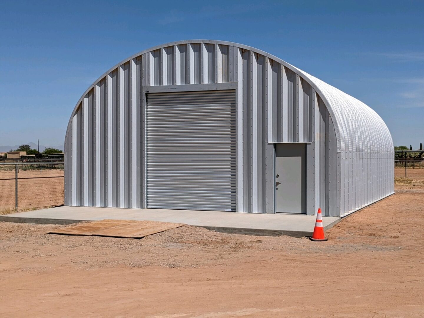 S-Model Quonset hut with a single traffic cone in front.