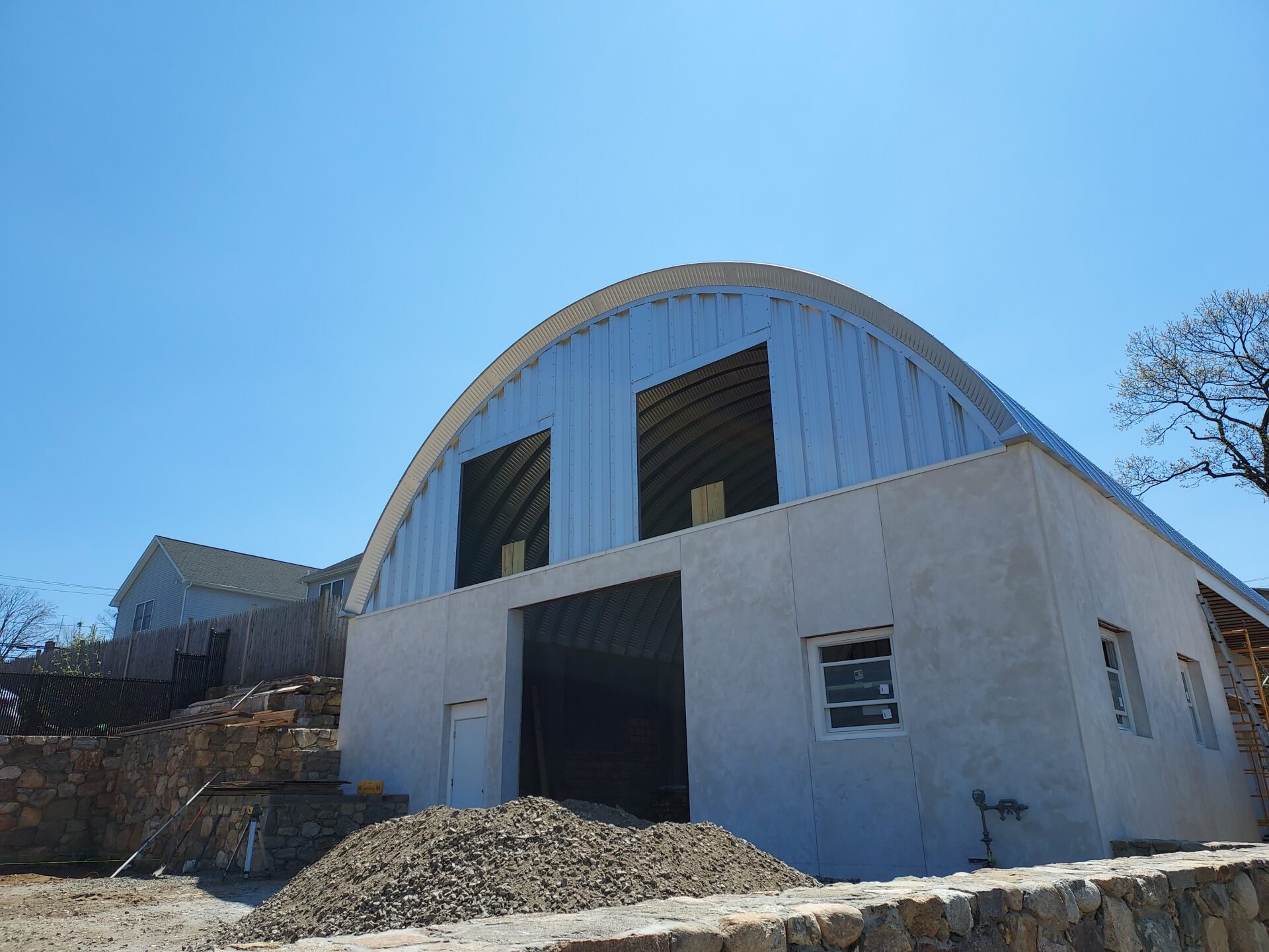 A steel Quonset with large cut outs on top of a concrete building structure