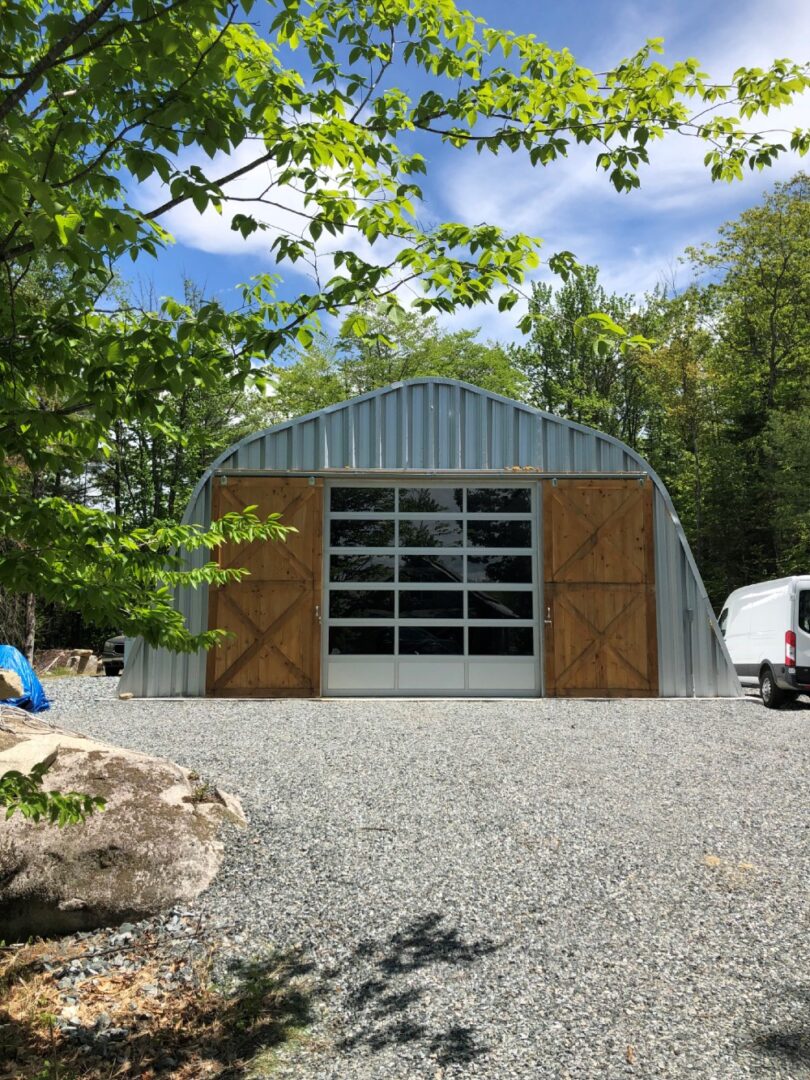 quonset hut with sliding wood doors, rolling garage door and steel endwall