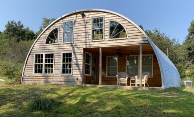 Q-Model house with light colored wooden end wall and custom windows