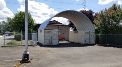 steel arch roof mounted on two brown shipping containers