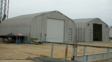 two industrial steel quonset hut storage buildings next to each other with white garage door