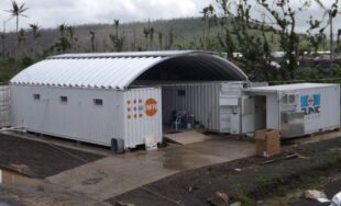 structure with a steel arch roof and two shipping containers made into a mobile hospital