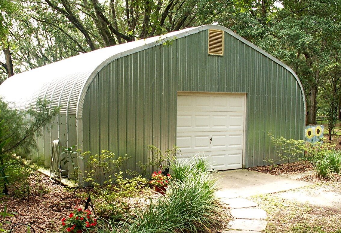 A-model Quonset hut with walkway, garden, and vent on the top of the end wall.