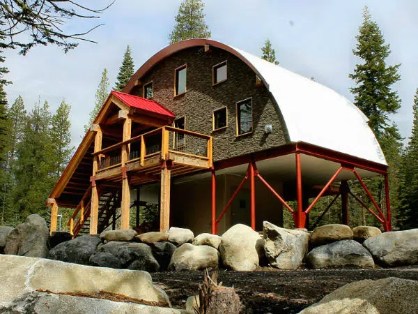 quonset hut home on raised pier foundation with wood steps in front